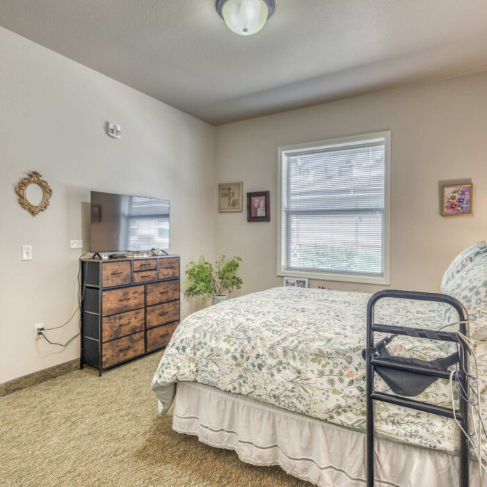 Another view of the floral bedroom showcasing natural light and warm atmosphere.