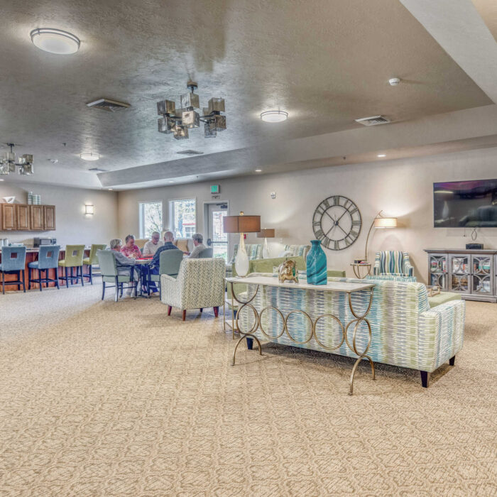 Spacious community room at Grace Assisted Living with seniors socializing at dining tables.