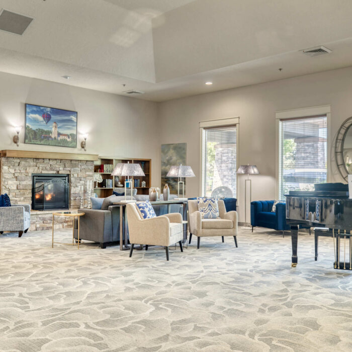 Charming assisted living library with fireplace and soft seating in Boise, ID