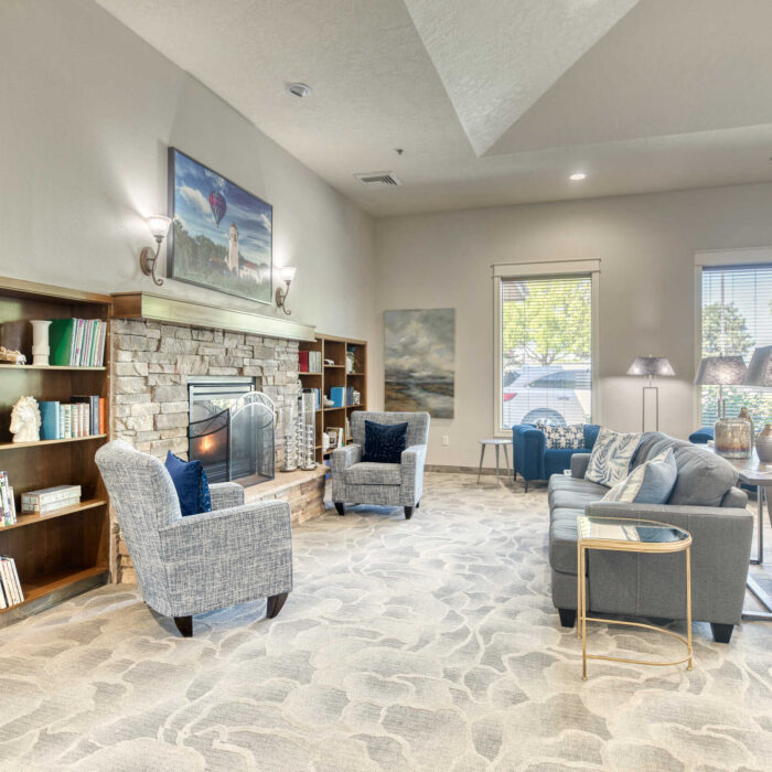 Comfortable senior living lounge with plush chairs and cozy fireplace in Boise