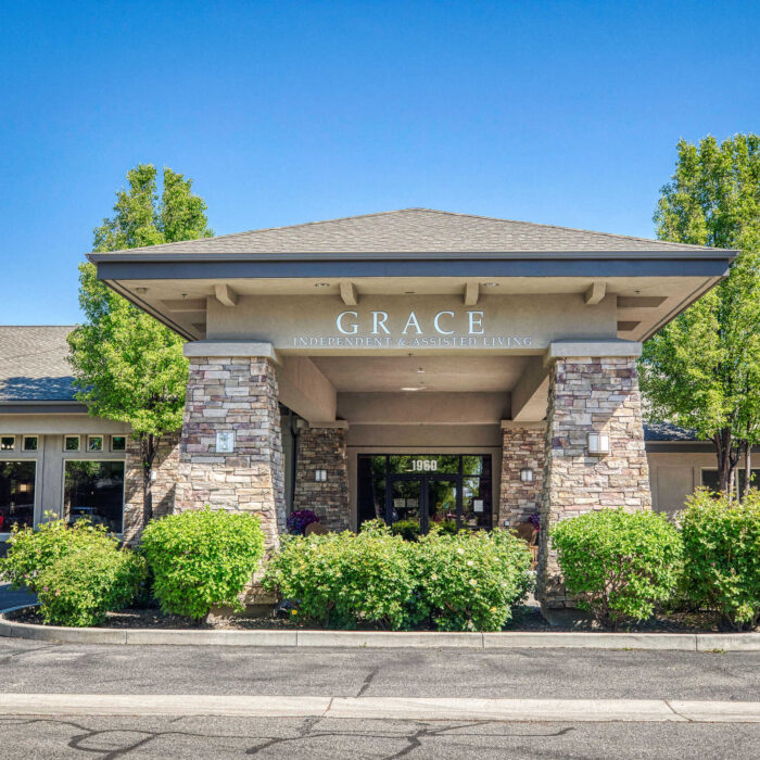 Grand entry with stone pillars and lush landscaping at Grace Assisted Living Meridian.