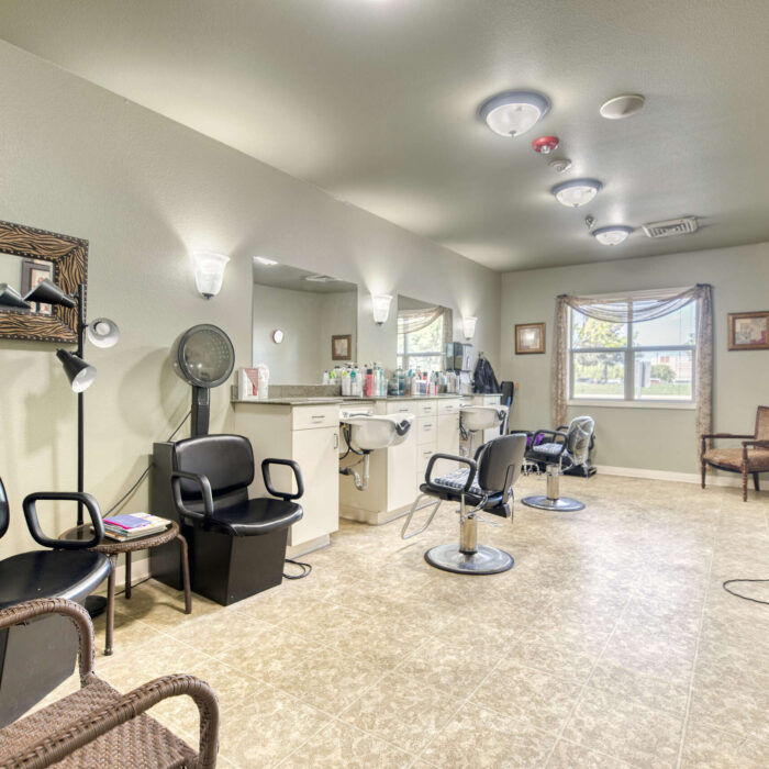 Spacious salon with styling chairs and professional equipment at Grace Assisted Living